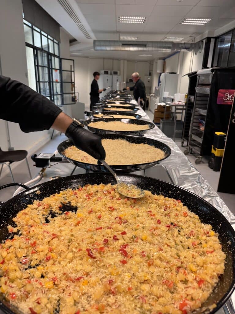 Grandes poêles de paella cuisinées sur un chantier des Champs-Élysées